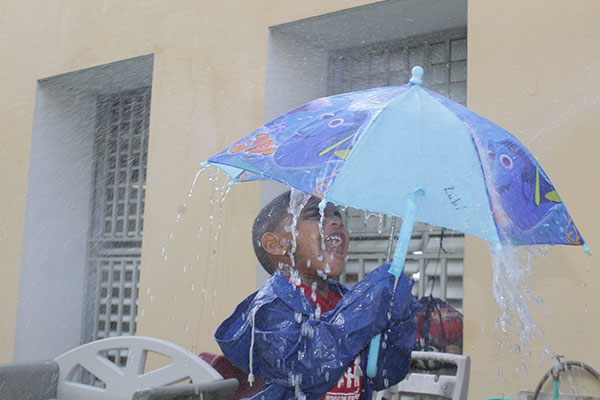 Niño con paraguas jugando bajo la lluvia