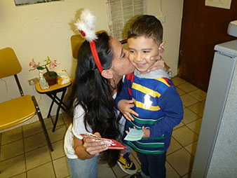 Mujer dándole un beso en la mejilla a un niño